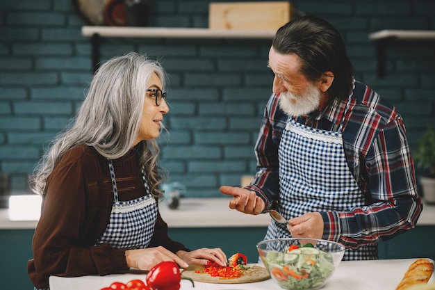 Coppia senior che prepara il cibo in cucina