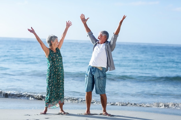 Senior couple raising arms