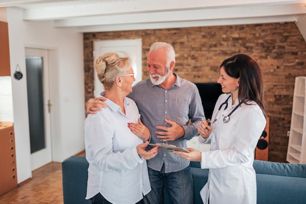 Senior couple receiving good news from a doctor.