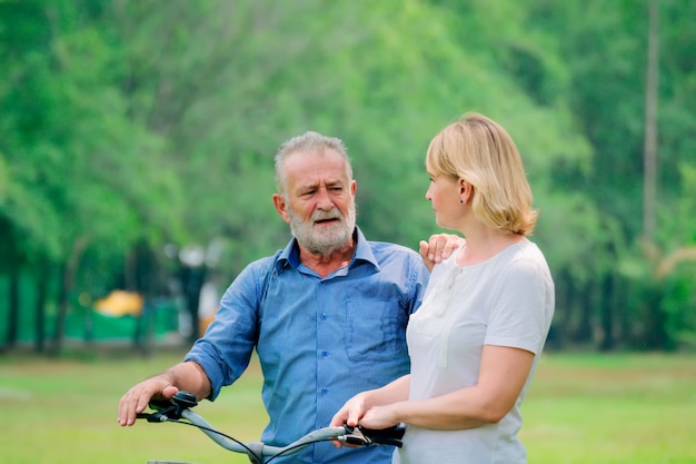 Senior couple relax lifestyle in the park with bicycle