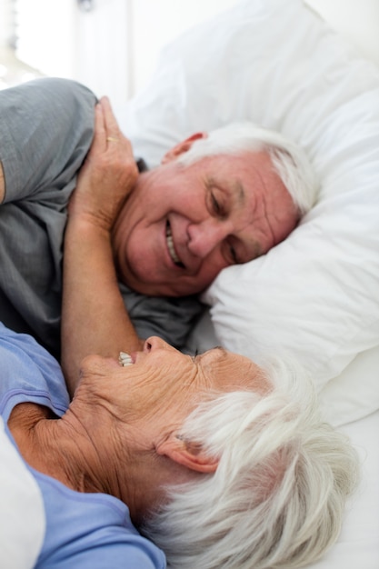 Foto coppia senior rilassante in camera da letto a casa