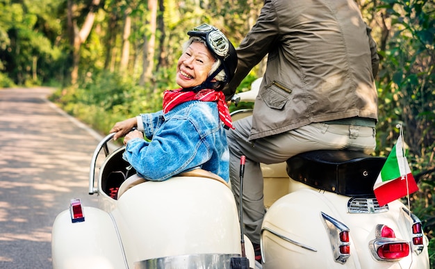 Senior couple riding a classic scooter