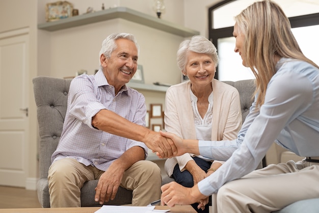 Senior couple shaking hands with financial advisor