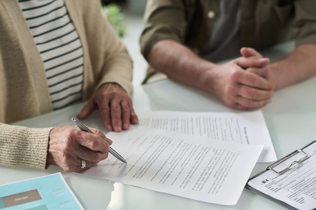 senior couple signing documents in office