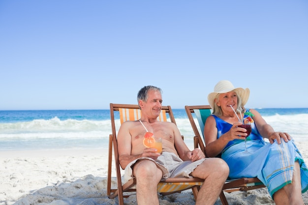 Senior couple sitting on deck chairs