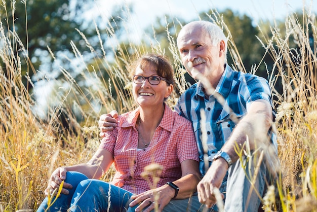 Photo senior couple sitting on field