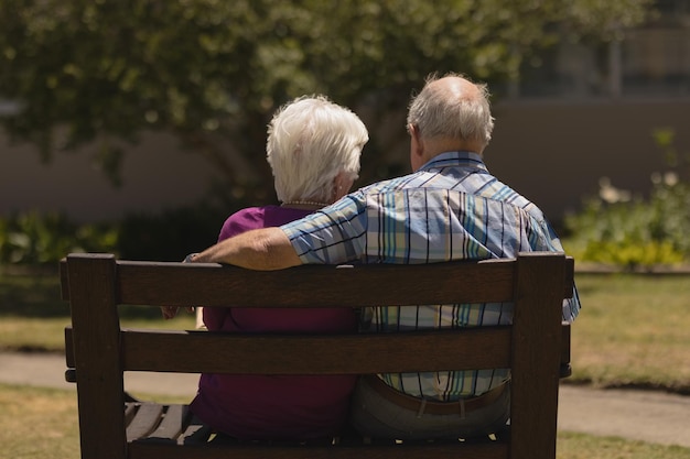 senior couple sitting together on the bench in the park