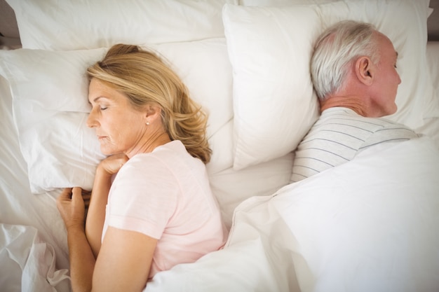 Senior couple sleeping on bed