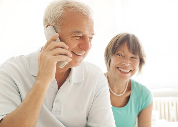 Photo senior couple speaking on the phone