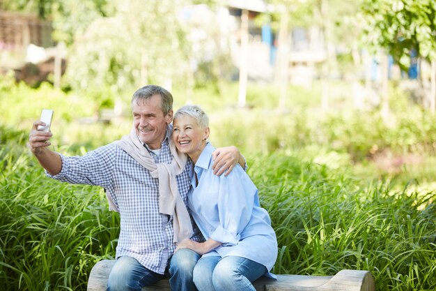 Photo senior couple taking selfie outdoors