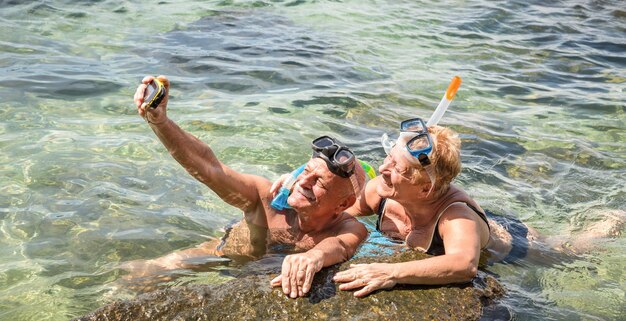 Photo senior couple taking selfie in sea