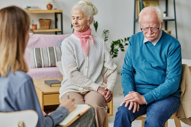 Senior couple talking to psychologist about their problems during psychotherapy session