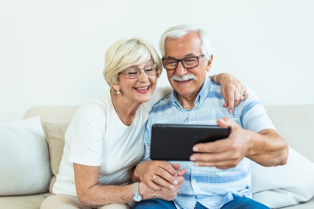 Senior couple using digital tablet at home