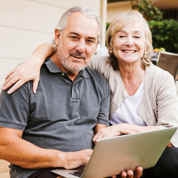 Senior couple using laptop in garden