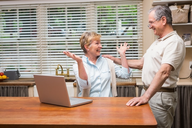 Senior couple using the laptop together