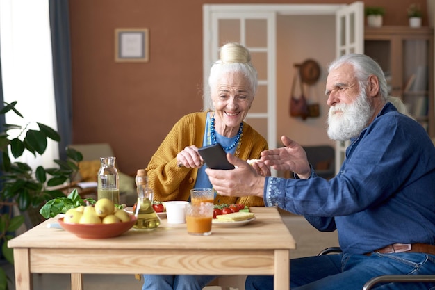 Senior couple using smartphone during breakfast