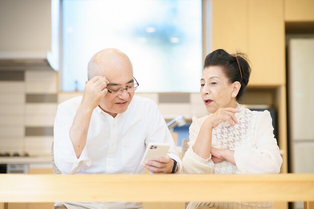 Senior couple using smartphones through trial and error in the room