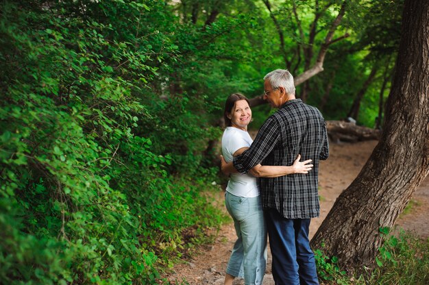 Senior couple walking together in a forest, close-up.