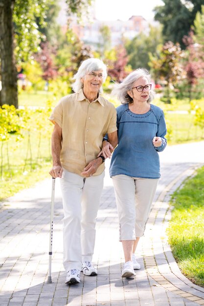 Пожилая пара с инвалидностью гуляет в парке