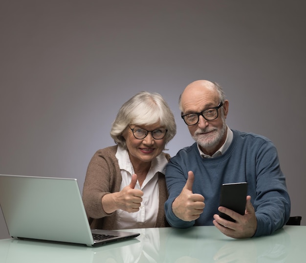 Senior couple with laptop and smartphone