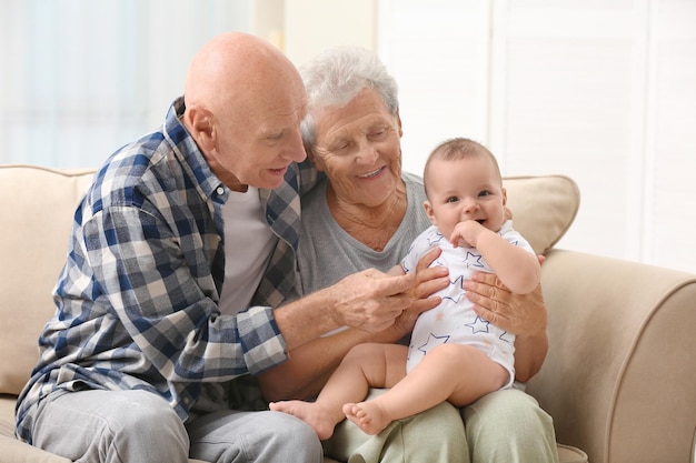 Photo senior couple with their little grandchild resting at home