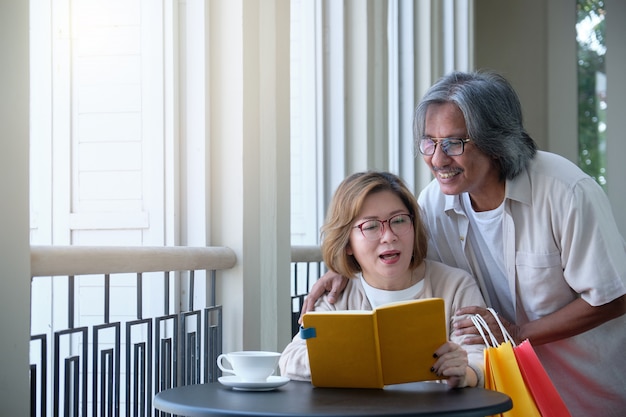 Senior couples go to shopping, read books and drink coffee on vacation, happy family concept.