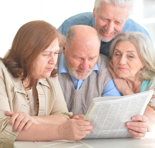 Senior couples reading newspaper