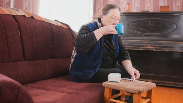 Senior dame - oudere vrouw die thuis drinkt uit een mok - pensioenleven, midle shot