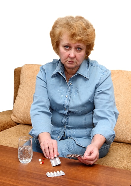 Senior dame vrouw met medicatie pillen in de kamer.