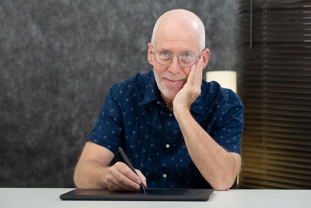 Старший дизайнер с помощью графического планшета в офисе