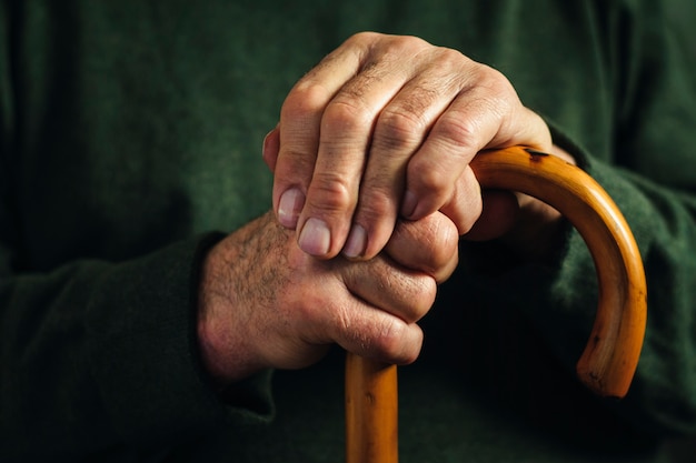 Senior disabled man clasping his walking stick