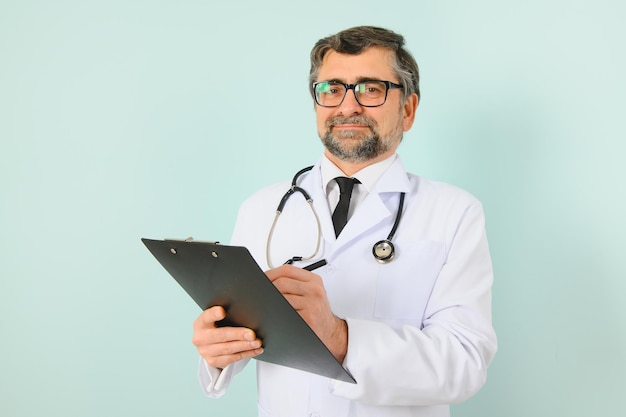 Senior doctor man wearing stethoscope and medical coat over blue background Cheerful expression