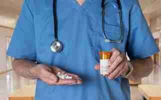 Photo senior doctor in scrubs with rx tablets