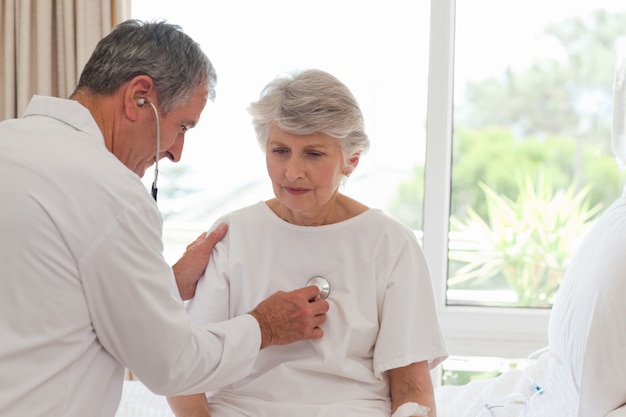 Photo senior doctor taking the heartbeat of his patient