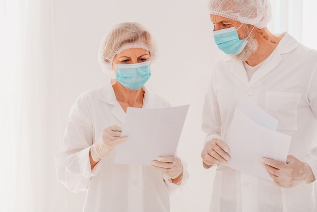 Medici anziani con maschera facciale lavorano insieme in ospedale