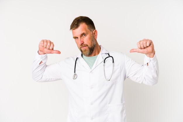 Senior dokter man geïsoleerd op een witte muur voelt zich trots en zelfverzekerd, voorbeeld om te volgen.