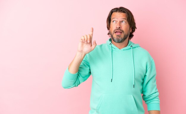 Senior dutch man isolated on pink background intending to realizes the solution while lifting a finger up