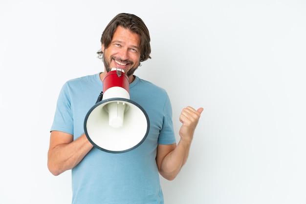 Senior dutch man isolated on white background shouting through a megaphone and pointing side