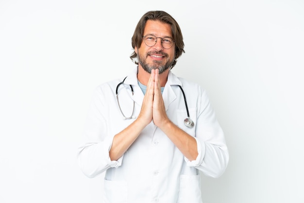 Senior dutch man isolated on white background wearing a doctor gown and pleading