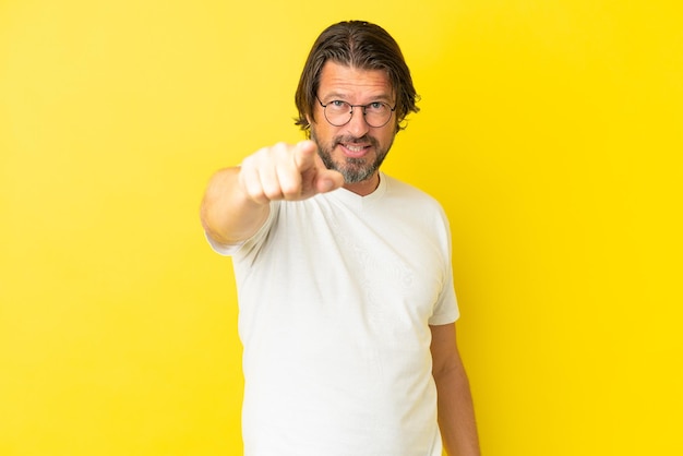 Senior dutch man isolated on yellow background frustrated and pointing to the front