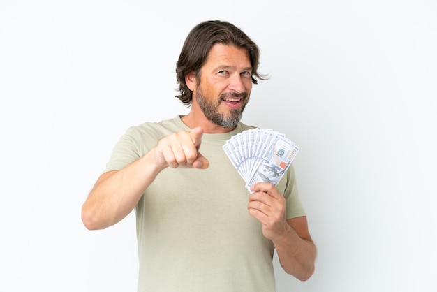 Senior dutch man taking a lot of money isolated on white background surprised and pointing front