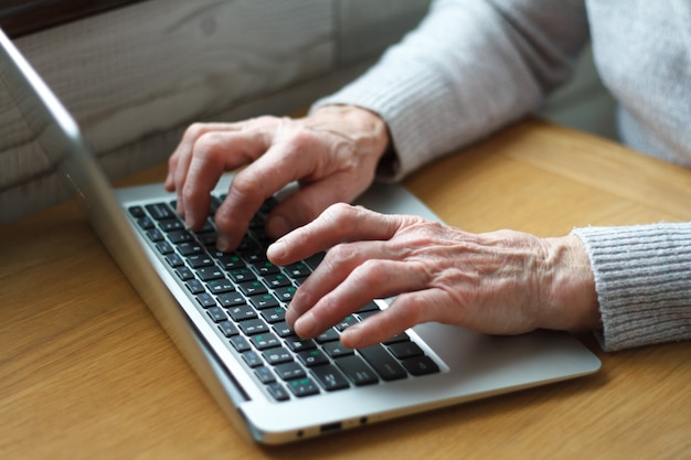 Senior elderly business woman working on laptop.