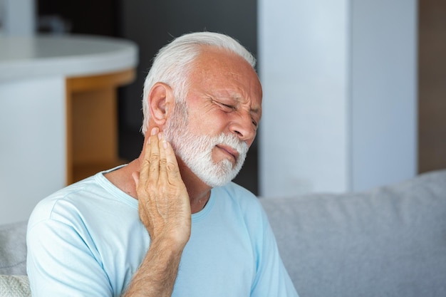 senior elderly man touching his neck suffering from neck pain sciatica sedentary lifestyle concept neck health problems healthcare insurance