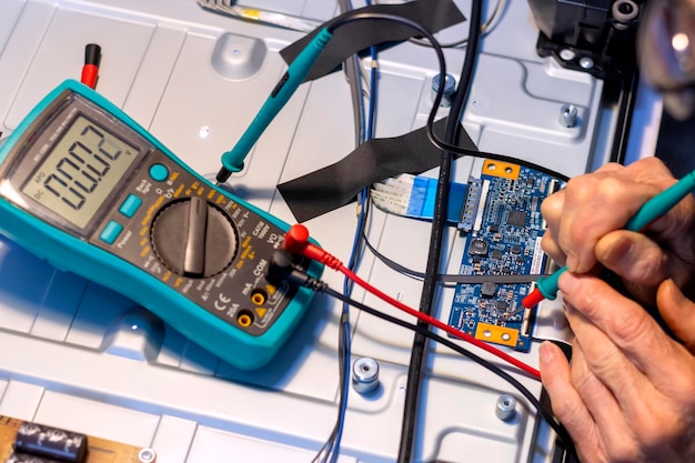 Senior elektronica technicus werkt met een tester