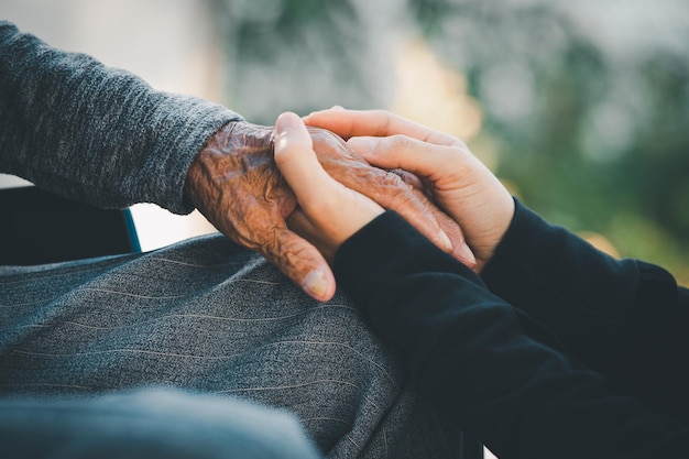 Foto senior en jonge vrouwen hand in hand zorgliefhebbers