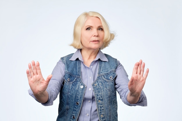 Senior european woman showing stop gesture