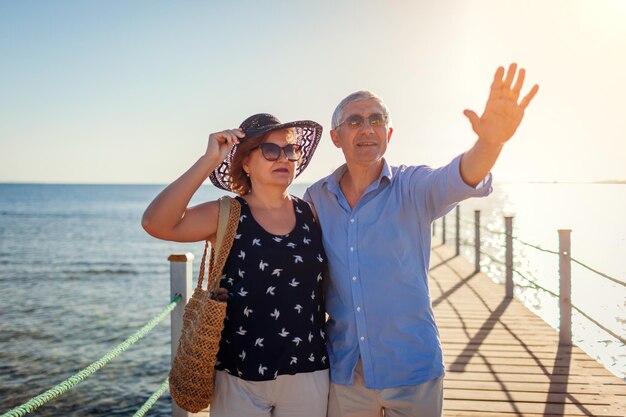 Senior family couple walking on pier by Red sea Retired people enjoying vacation in tropical Egypt enjoying landscape