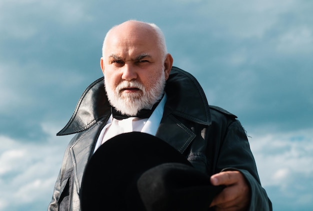 Фото Старший модник стильный и модный бородатый пожилой мужчина в кожаной куртке и современной шляпе деловой стиль модный мужчина