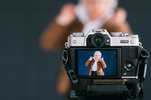 Photo senior fashion stylist blogger. aged lady in trendy autumn outfit shooting vlog.