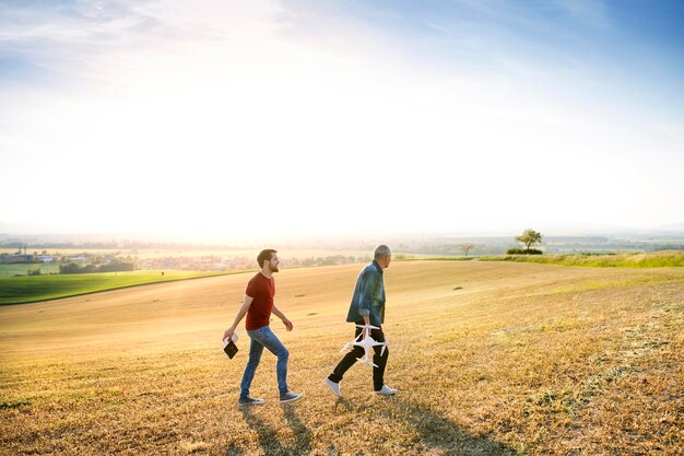 Senior father and his adult son with drone on a field